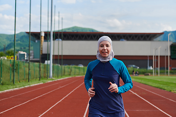 Image showing A muslim woman in a burqa sports muslim clothes running on a marathon course and preparing for upcoming competitions