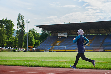 Image showing A muslim woman in a burqa sports muslim clothes running on a marathon course and preparing for upcoming competitions