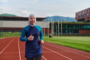 Image showing A muslim woman in a burqa sports muslim clothes running on a marathon course and preparing for upcoming competitions