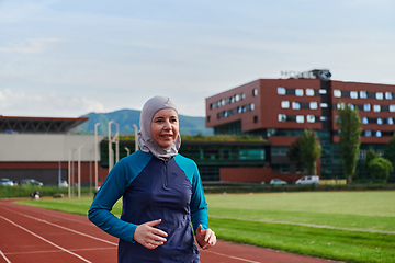 Image showing A muslim woman in a burqa sports muslim clothes running on a marathon course and preparing for upcoming competitions