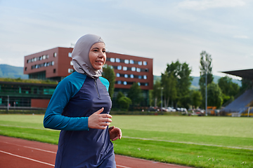 Image showing A muslim woman in a burqa sports muslim clothes running on a marathon course and preparing for upcoming competitions