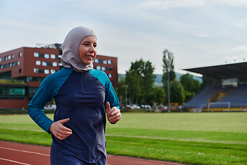 Image showing A muslim woman in a burqa sports muslim clothes running on a marathon course and preparing for upcoming competitions