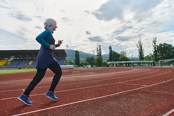 Image showing A muslim woman in a burqa sports muslim clothes running on a marathon course and preparing for upcoming competitions