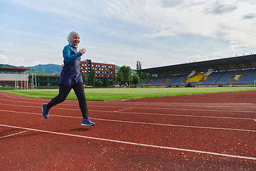 Image showing A muslim woman in a burqa sports muslim clothes running on a marathon course and preparing for upcoming competitions