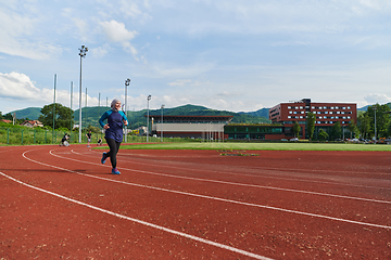 Image showing A muslim woman in a burqa sports muslim clothes running on a marathon course and preparing for upcoming competitions