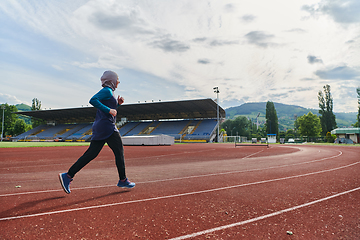 Image showing A muslim woman in a burqa sports muslim clothes running on a marathon course and preparing for upcoming competitions