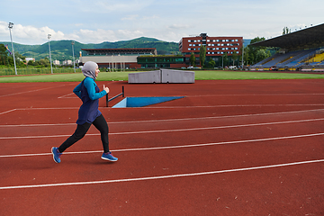 Image showing A muslim woman in a burqa sports muslim clothes running on a marathon course and preparing for upcoming competitions