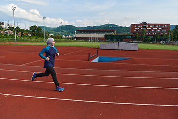 Image showing A muslim woman in a burqa sports muslim clothes running on a marathon course and preparing for upcoming competitions