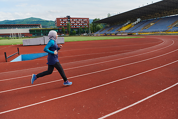 Image showing A muslim woman in a burqa sports muslim clothes running on a marathon course and preparing for upcoming competitions