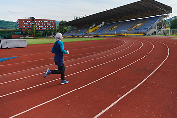 Image showing A muslim woman in a burqa sports muslim clothes running on a marathon course and preparing for upcoming competitions