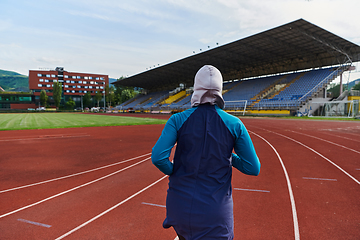 Image showing A muslim woman in a burqa sports muslim clothes running on a marathon course and preparing for upcoming competitions