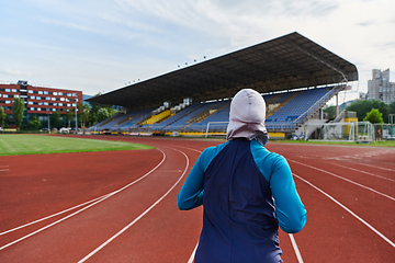 Image showing A muslim woman in a burqa sports muslim clothes running on a marathon course and preparing for upcoming competitions