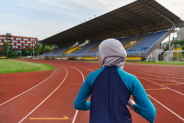 Image showing A muslim woman in a burqa sports muslim clothes running on a marathon course and preparing for upcoming competitions