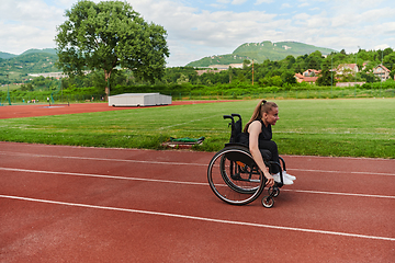 Image showing A woman with disablity driving a wheelchair on a track while preparing for the Paralympic Games