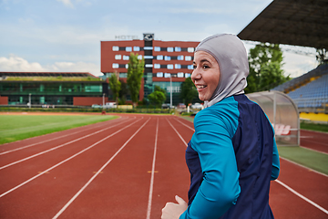 Image showing A muslim woman in a burqa sports muslim clothes running on a marathon course and preparing for upcoming competitions