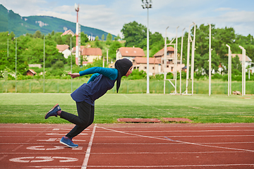 Image showing A muslim woman in a burqa sports muslim clothes running on a marathon course and preparing for upcoming competitions