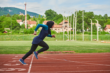 Image showing A muslim woman in a burqa sports muslim clothes running on a marathon course and preparing for upcoming competitions