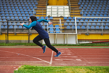 Image showing A muslim woman in a burqa sports muslim clothes running on a marathon course and preparing for upcoming competitions