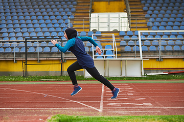 Image showing A muslim woman in a burqa sports muslim clothes running on a marathon course and preparing for upcoming competitions