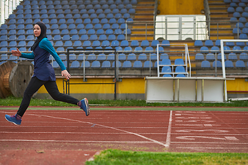 Image showing A muslim woman in a burqa sports muslim clothes running on a marathon course and preparing for upcoming competitions