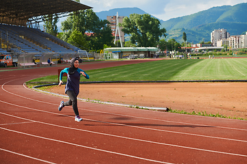 Image showing A muslim woman in a burqa sports muslim clothes running on a marathon course and preparing for upcoming competitions