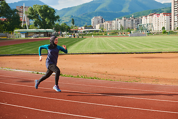 Image showing A muslim woman in a burqa sports muslim clothes running on a marathon course and preparing for upcoming competitions