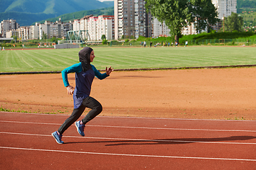 Image showing A muslim woman in a burqa sports muslim clothes running on a marathon course and preparing for upcoming competitions