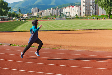 Image showing A muslim woman in a burqa sports muslim clothes running on a marathon course and preparing for upcoming competitions