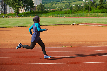 Image showing A muslim woman in a burqa sports muslim clothes running on a marathon course and preparing for upcoming competitions