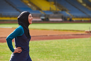 Image showing A Muslim woman with a burqa, an Islamic sportswoman resting after a vigorous training session on the marathon course. A hijab woman is preparing for a marathon competition