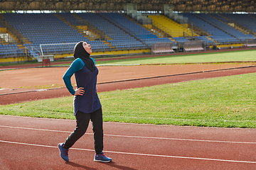 Image showing A Muslim woman with a burqa, an Islamic sportswoman resting after a vigorous training session on the marathon course. A hijab woman is preparing for a marathon competition