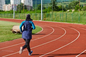 Image showing A muslim woman in a burqa sports muslim clothes running on a marathon course and preparing for upcoming competitions