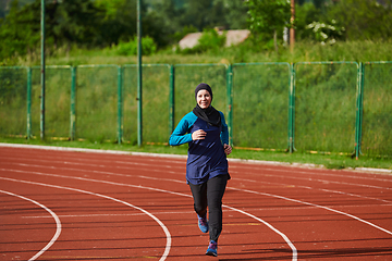 Image showing A muslim woman in a burqa sports muslim clothes running on a marathon course and preparing for upcoming competitions