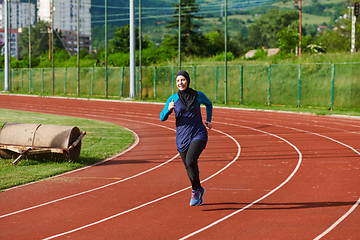 Image showing A muslim woman in a burqa sports muslim clothes running on a marathon course and preparing for upcoming competitions