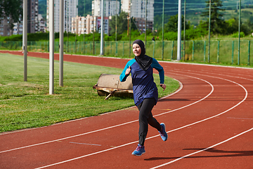 Image showing A muslim woman in a burqa sports muslim clothes running on a marathon course and preparing for upcoming competitions