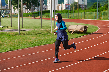 Image showing A muslim woman in a burqa sports muslim clothes running on a marathon course and preparing for upcoming competitions