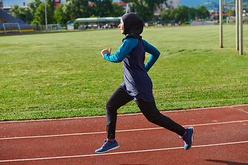 Image showing A muslim woman in a burqa sports muslim clothes running on a marathon course and preparing for upcoming competitions