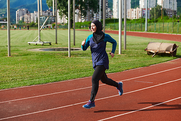 Image showing A muslim woman in a burqa sports muslim clothes running on a marathon course and preparing for upcoming competitions