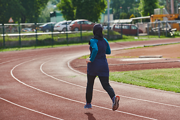 Image showing A muslim woman in a burqa sports muslim clothes running on a marathon course and preparing for upcoming competitions