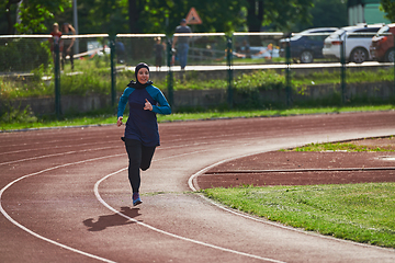 Image showing A muslim woman in a burqa sports muslim clothes running on a marathon course and preparing for upcoming competitions