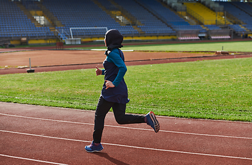 Image showing A muslim woman in a burqa sports muslim clothes running on a marathon course and preparing for upcoming competitions