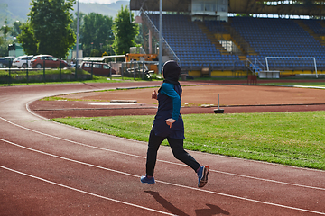 Image showing A muslim woman in a burqa sports muslim clothes running on a marathon course and preparing for upcoming competitions