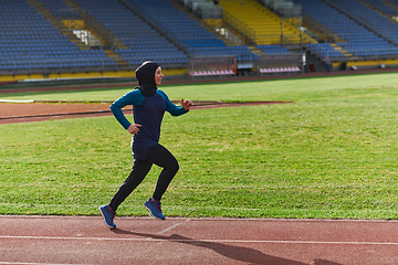 Image showing A muslim woman in a burqa sports muslim clothes running on a marathon course and preparing for upcoming competitions