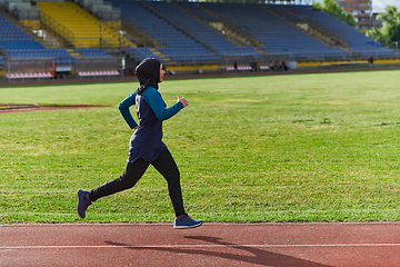 Image showing A muslim woman in a burqa sports muslim clothes running on a marathon course and preparing for upcoming competitions