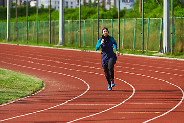 Image showing A muslim woman in a burqa sports muslim clothes running on a marathon course and preparing for upcoming competitions