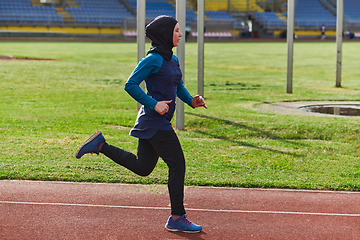 Image showing A muslim woman in a burqa sports muslim clothes running on a marathon course and preparing for upcoming competitions