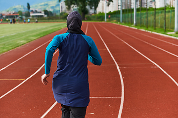 Image showing A muslim woman in a burqa sports muslim clothes running on a marathon course and preparing for upcoming competitions