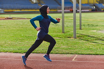 Image showing A muslim woman in a burqa sports muslim clothes running on a marathon course and preparing for upcoming competitions