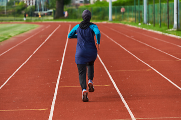 Image showing A muslim woman in a burqa sports muslim clothes running on a marathon course and preparing for upcoming competitions