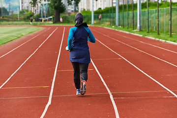 Image showing A muslim woman in a burqa sports muslim clothes running on a marathon course and preparing for upcoming competitions